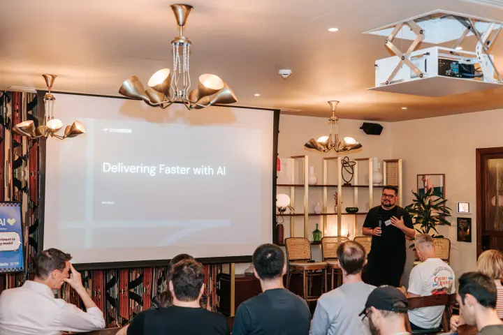 Attendees watching a presentation about delivering faster with AI